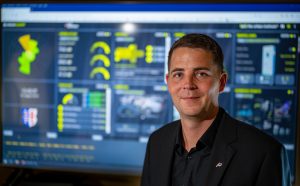 Martin Steimar steht vor einem gro&szlig;en Monitor, auf dem zahlreiche Daten im Urban Cockpit zusammenlaufen und visualisiert werden.